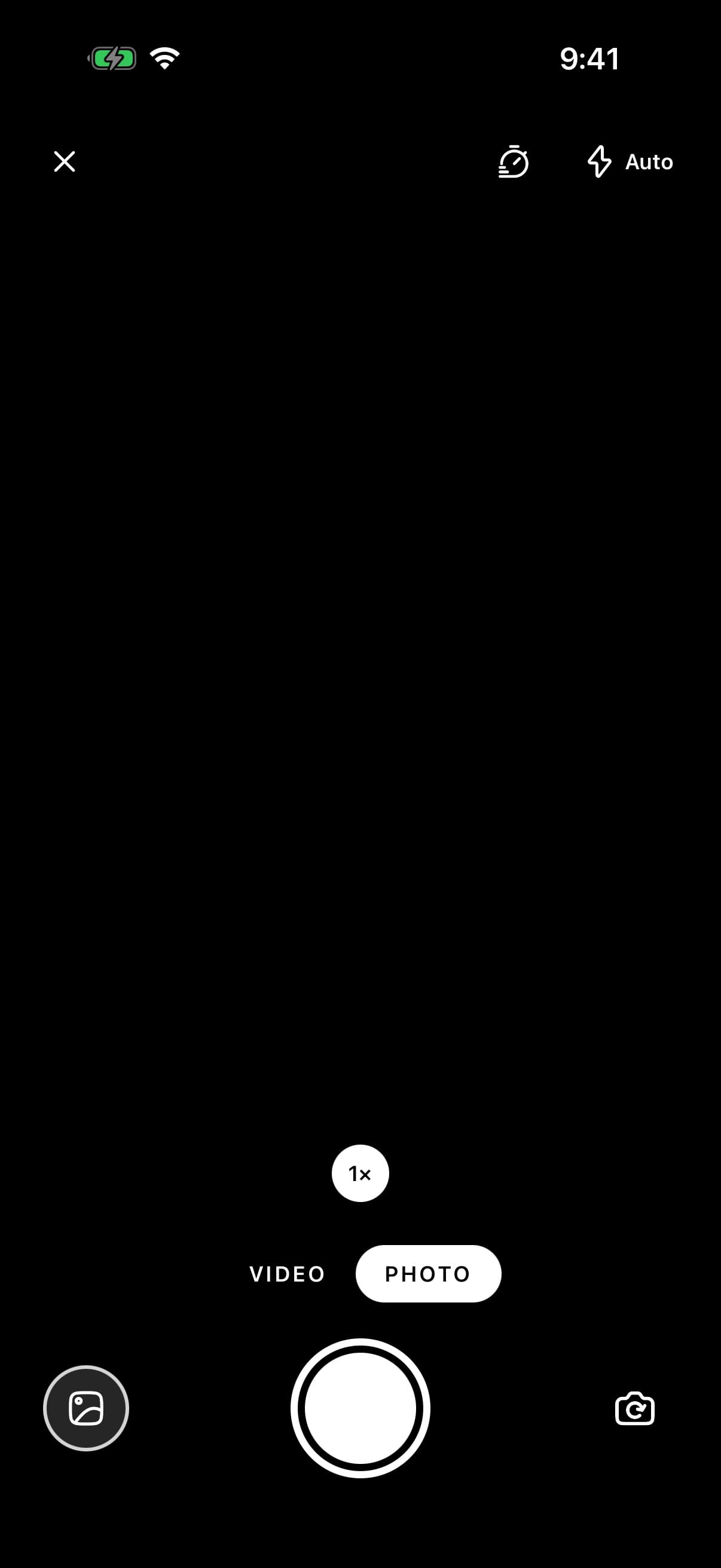 Camera in photo mode over a black viewfinder. Along the top, a close button, the timer, and the flash set to Auto. Along the bottom, a 1× zoom chip, the Video and Photo modes, and the library button, a white shutter and the switch-camera button.