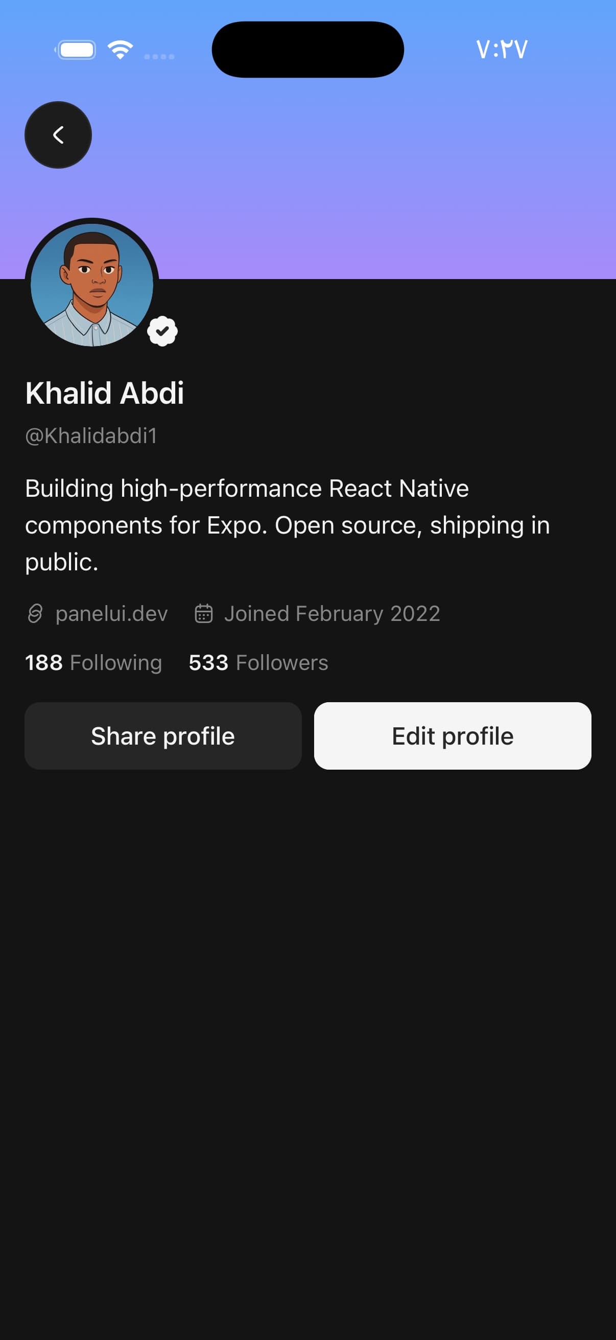 A profile screen on a dark phone: a blue-to-violet gradient banner, a round photograph overlapping its bottom edge with a verification rosette, the name, the handle, a bio, a link and a joined date, the counts 188 Following and 533 Followers, and the buttons Share profile and Edit profile.